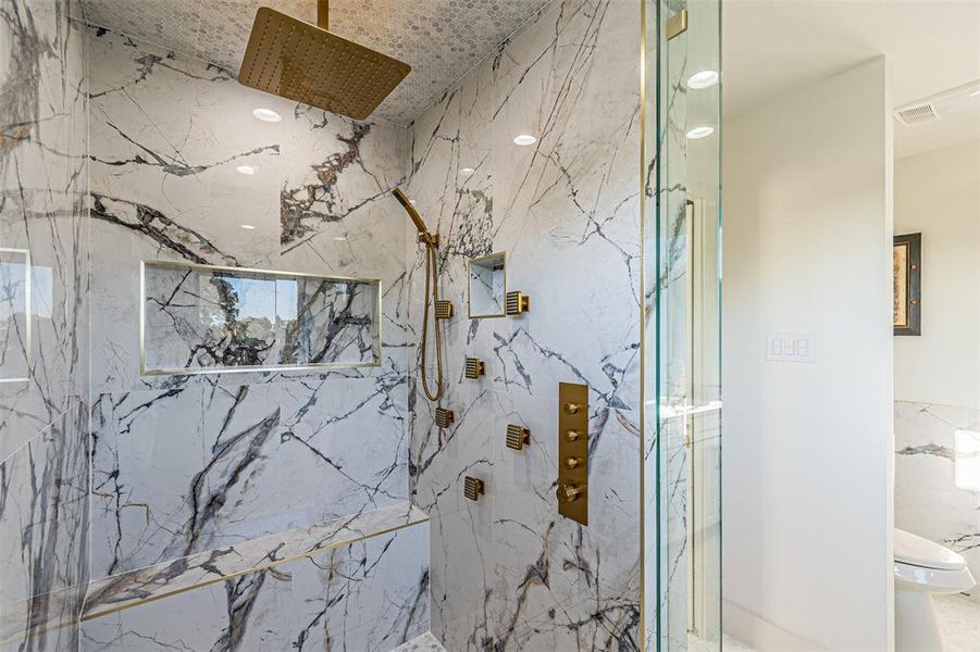 Full bath featuring a marble finish shower and toilet