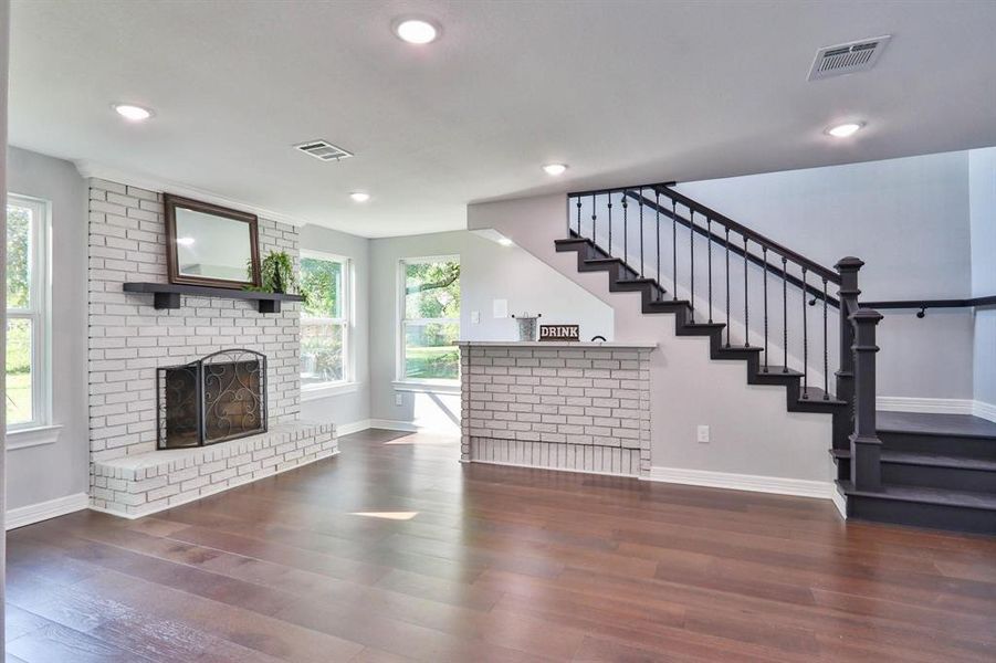 Carefree Contemporary Living. Charming floor-to-ceiling brick wood burning fireplace in the den; wrought-iron staircase leading to second level.