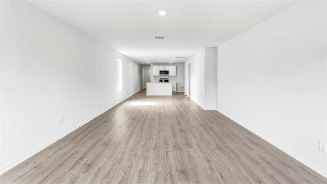 Unfurnished living room featuring light wood finished floors and recessed lighting Unfurnished living room featuring light wood finished floors and recessed lighting
