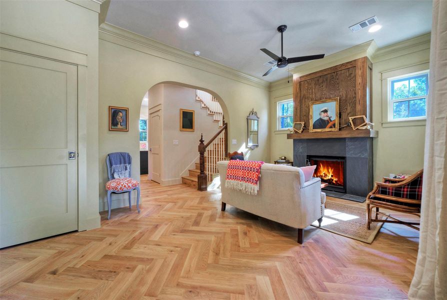 What an entry! Craftsmanship is next-level with crown molding, herringbone oak flooring, archway, and beautiful fireplace.