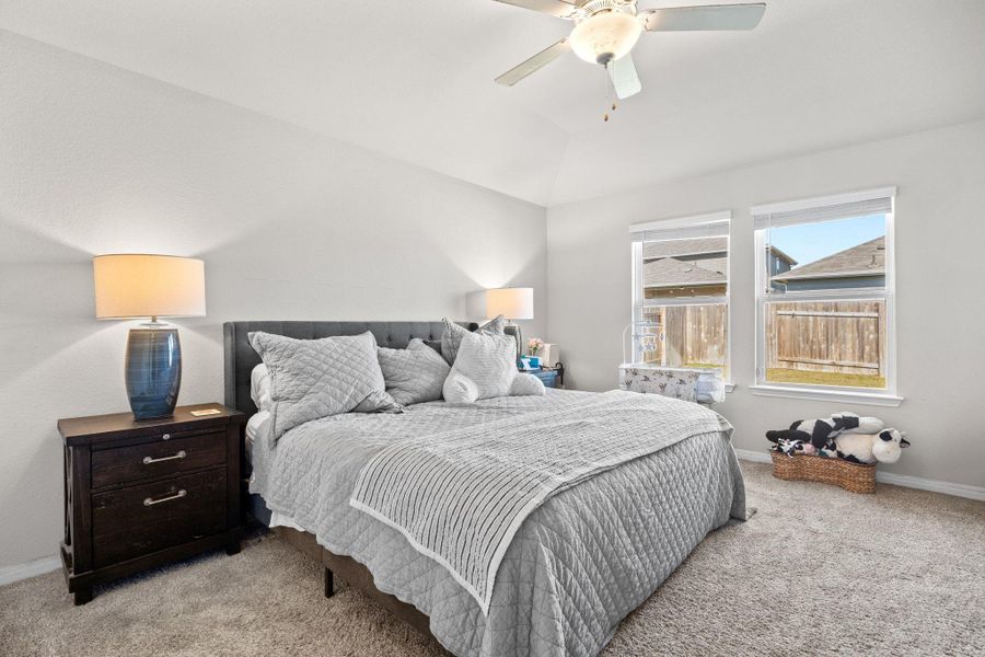 Bedroom with light carpet, ceiling fan, and vaulted ceiling Bedroom with light carpet, ceiling fan, and vaulted ceiling