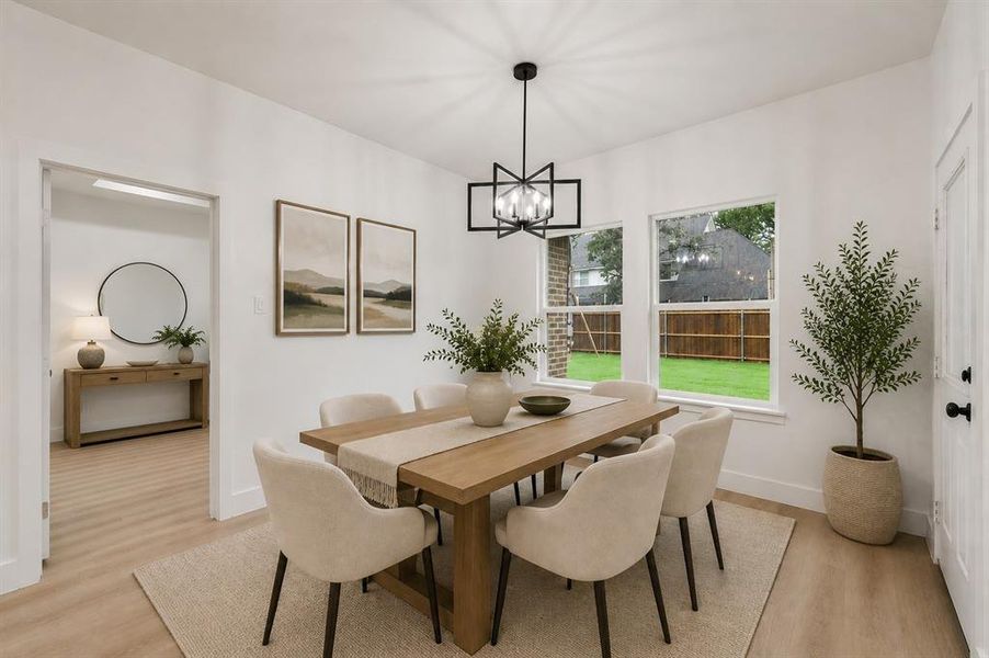 Dining area featuring a contemporary chandelier, two large windows, wood-finish flooring, and crisp white walls Dining area featuring a contemporary chandelier, two large windows, wood-finish flooring, and crisp white walls