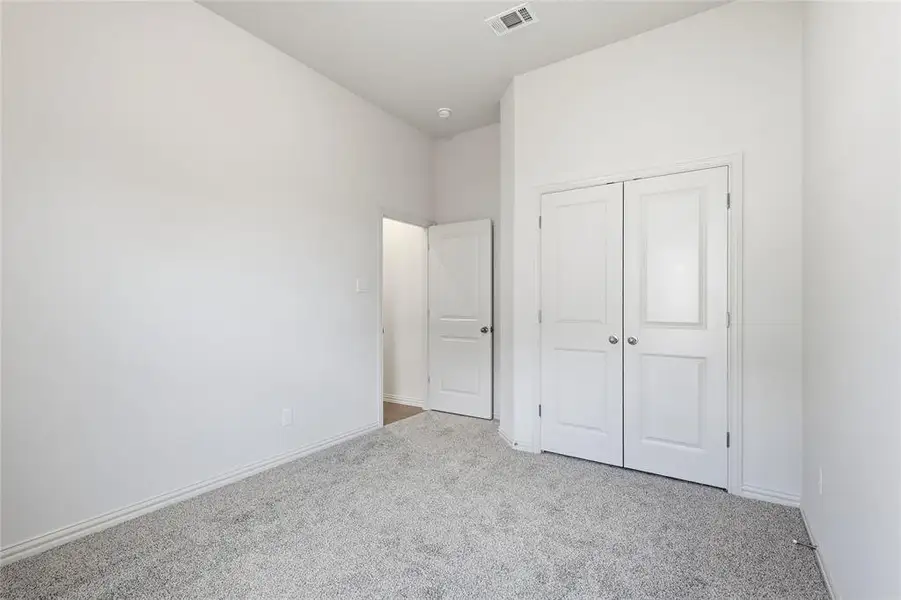 Unfurnished bedroom featuring light colored carpet and a closet Unfurnished bedroom featuring light colored carpet and a closet