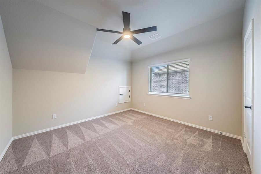 Carpeted room with a modern ceiling fan and light fixture