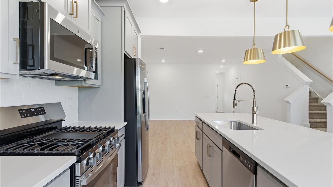 Elegant kitchen with large island and pendant lighting in this first-class DRB Homes design