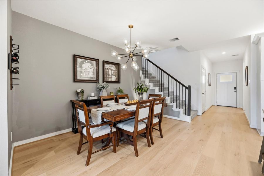 Dining area open to the entry and staircase, showing the flow from the front door into the living space.