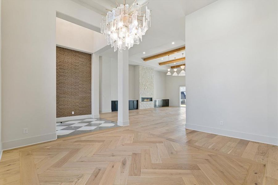 Unfurnished living room featuring recessed lighting, a chandelier, a fireplace, and beamed ceiling