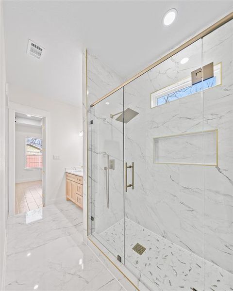 Bathroom featuring a marble finish shower, vanity, light marble finish floors, and recessed lighting Bathroom featuring a marble finish shower, vanity, light marble finish floors, and recessed lighting