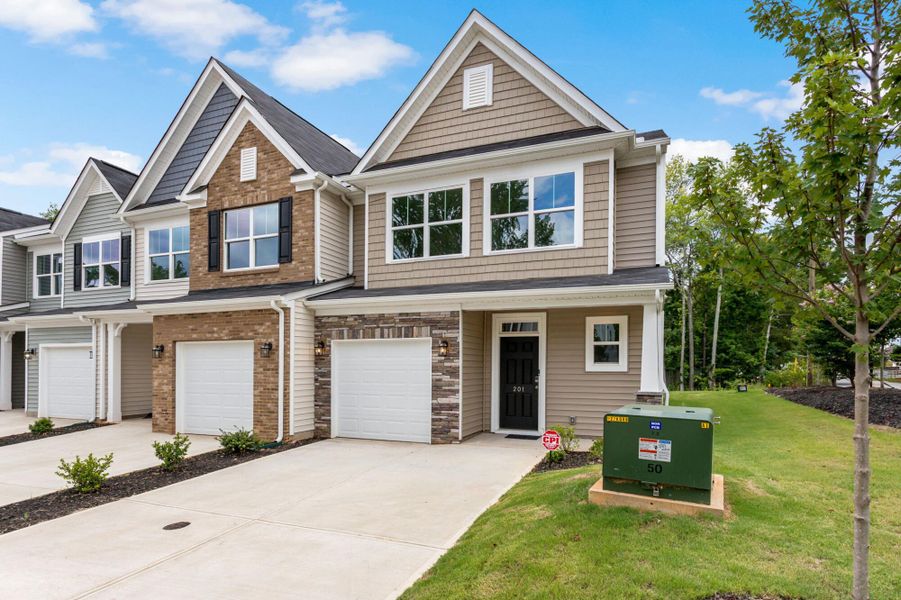 Front exterior of a new home in East Main Townes, Spartanburg, SC, highlighting curb appeal (Image 2). Front exterior of a new home in East Main Townes, Spartanburg, SC, highlighting curb appeal (Image 2).