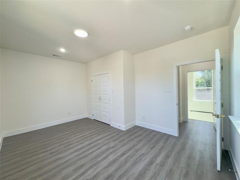 Unfurnished bedroom with dark hardwood / wood-style floors and a closet