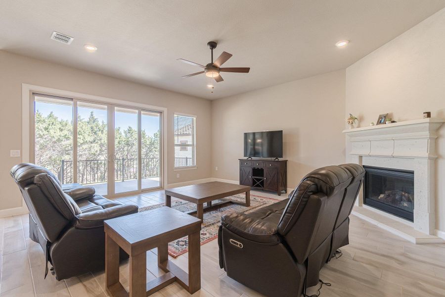 Living room with recessed lighting, visible vents, a high end fireplace, ceiling fan, and baseboards