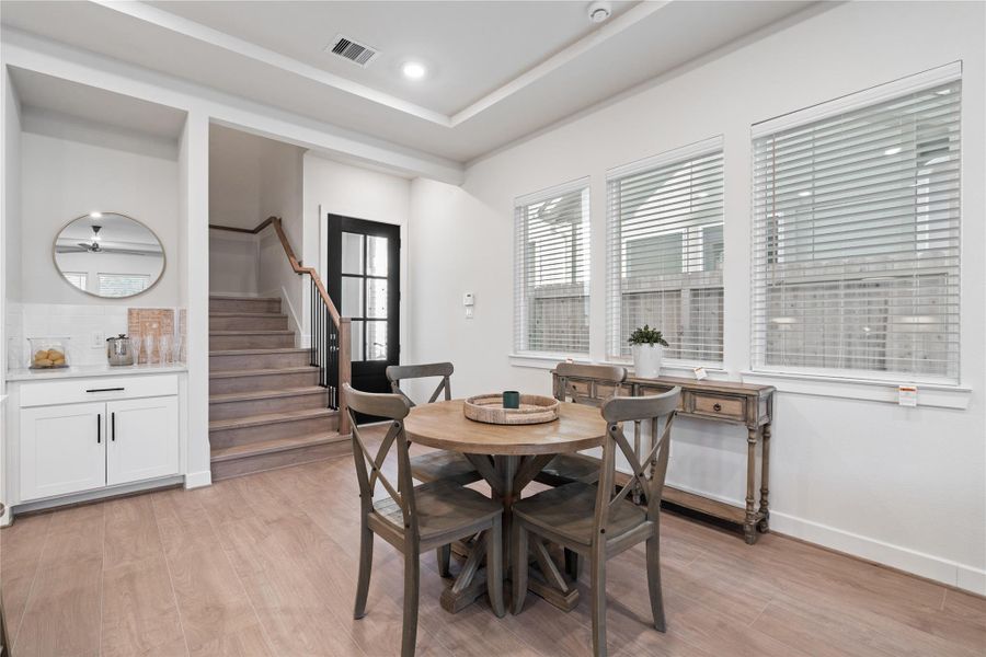 Defined dining area positioned between the living and kitchen, with a built in dry bar that adds practical storage and counter space.