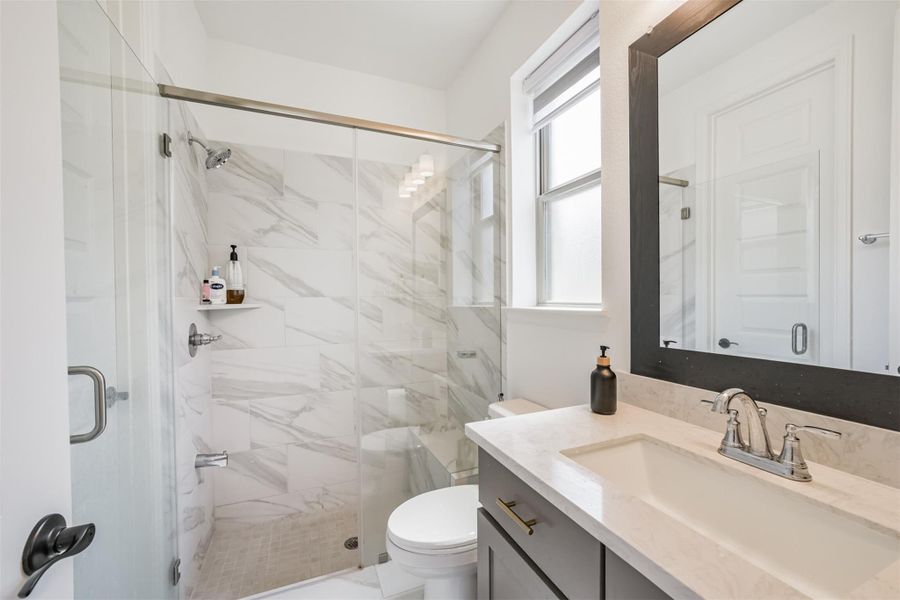 A second bathroom located downstairs, featuring a walk-in shower for added convenience. A second bathroom located downstairs, featuring a walk-in shower for added convenience.
