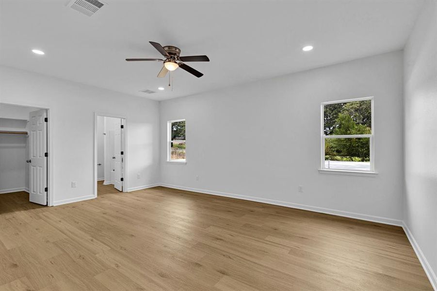 Unfurnished bedroom with a spacious closet, recessed lighting, light wood-style flooring, and a ceiling fan Unfurnished bedroom with a spacious closet, recessed lighting, light wood-style flooring, and a ceiling fan