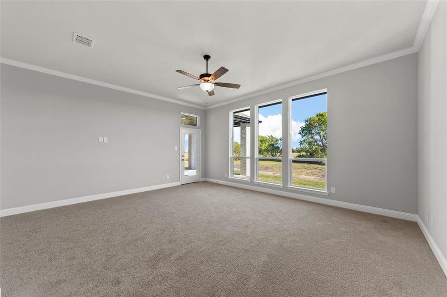 Unfurnished room with carpet flooring, ornamental molding, and ceiling fan