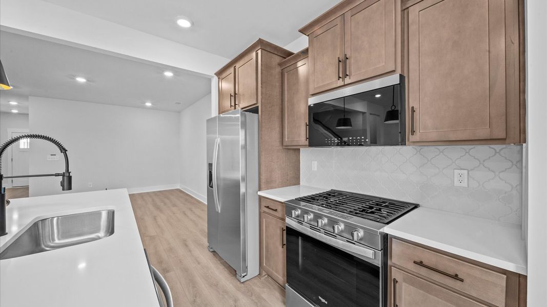 Wooden cabinetry kitchen with backsplash in two story townhome at Ransdell Pointe by DRB Homes in Spartanburg, SC