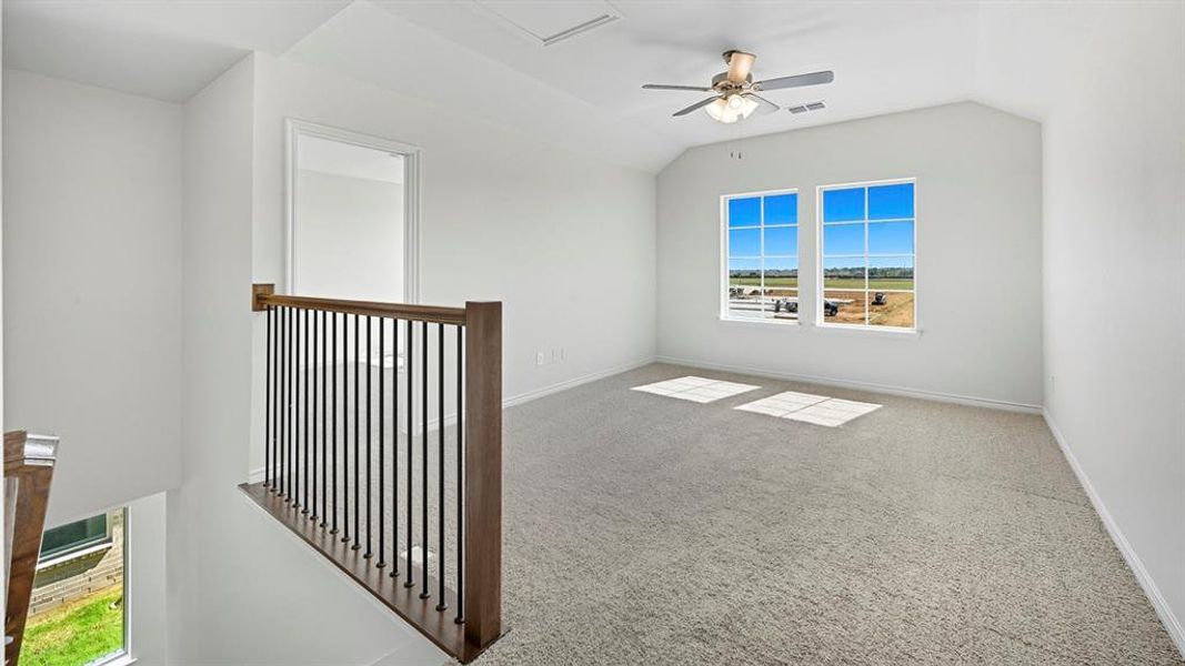Spare room with carpet flooring, lofted ceiling, and ceiling fan