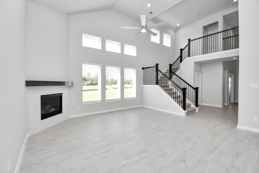 Gather the family and guests together in your lovely living room! Featuring soaring high ceilings, recessed lighting, ceiling fan, custom paint, gorgeous floors, and large windows that provide plenty of natural lighting throughout the day. Sample photo of completed home with similar floor plan. Actual colors and selections may vary. Gather the family and guests together in your lovely living room! Featuring soaring high ceilings, recessed lighting, ceiling fan, custom paint, gorgeous floors, and large windows that provide plenty of natural lighting throughout the day. Sample photo of completed home with similar floor plan. Actual colors and selections may vary.