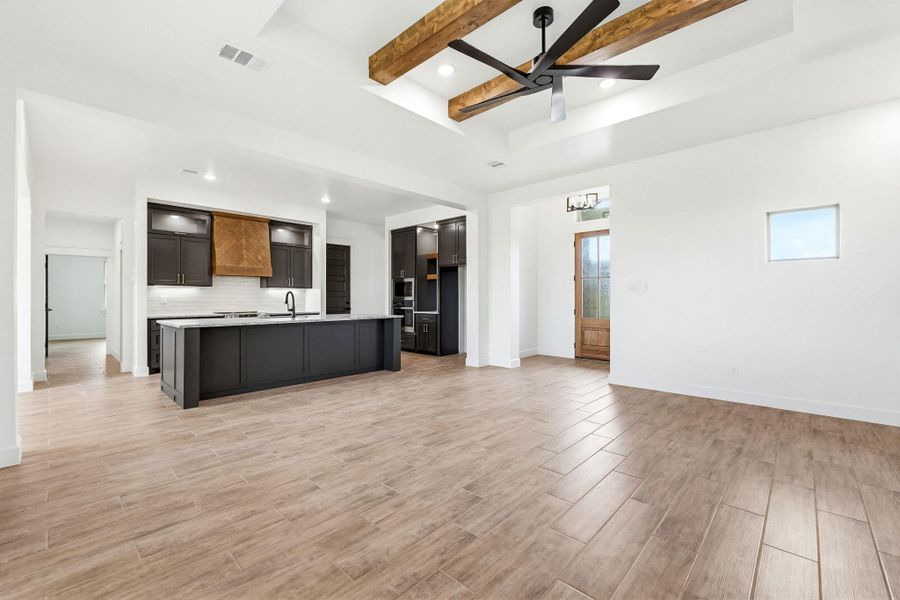 An open-concept living space highlights a streamlined kitchen with an island and integrated appliances. An open-concept living space highlights a streamlined kitchen with an island and integrated appliances.