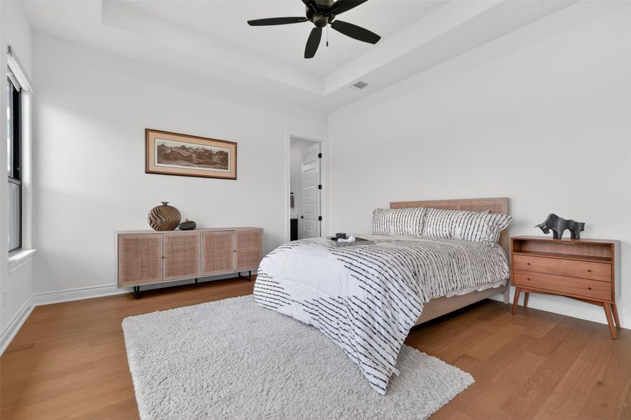 Hardwood flooring and a vaulted ceiling elevate this comfortable primary bedroom retreat. Hardwood flooring and a vaulted ceiling elevate this comfortable primary bedroom retreat.