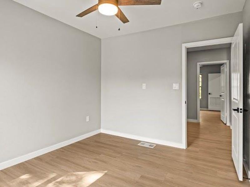 Spare room with light wood finished floors and ceiling fan
