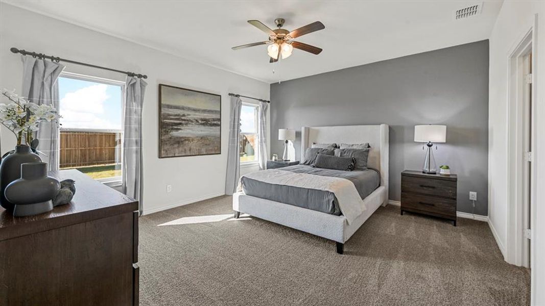 Spacious room featuring broadloom carpeting, a ceiling fan with integrated lighting, and a prominent accent wall