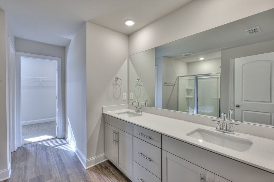 The primary bathroom offers dual vanity sinks and a walk-in closet.