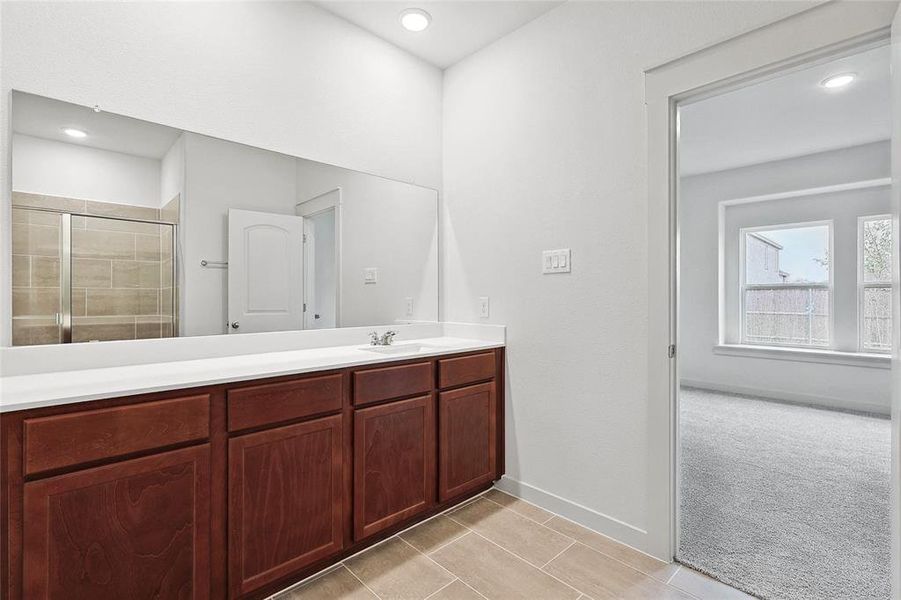 Bathroom with walk in shower, tile patterned flooring, and vanity