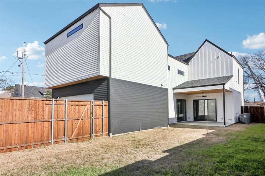 Back of property featuring ceiling fan, a patio, and a yard