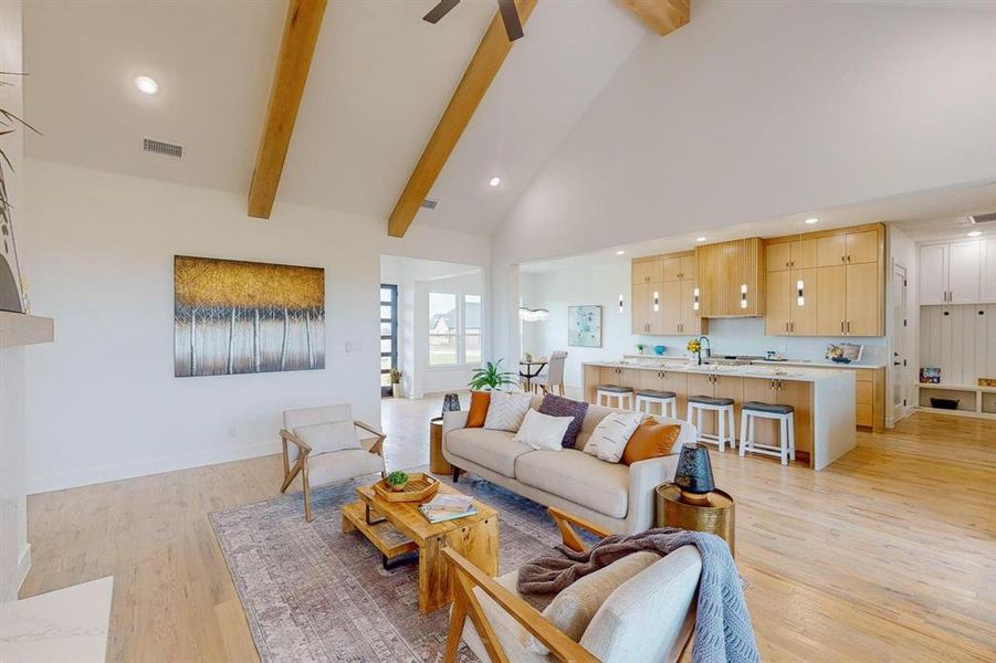 Living room featuring light wood-type flooring, ceiling fan, high vaulted ceiling, and beam ceiling