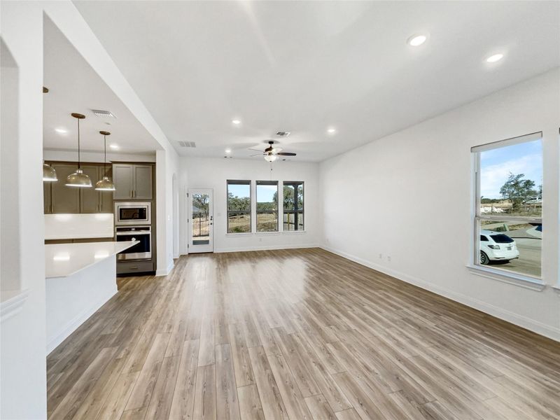 Unfurnished living room featuring visible vents, light wood-style flooring, a ceiling fan, recessed lighting, and baseboards