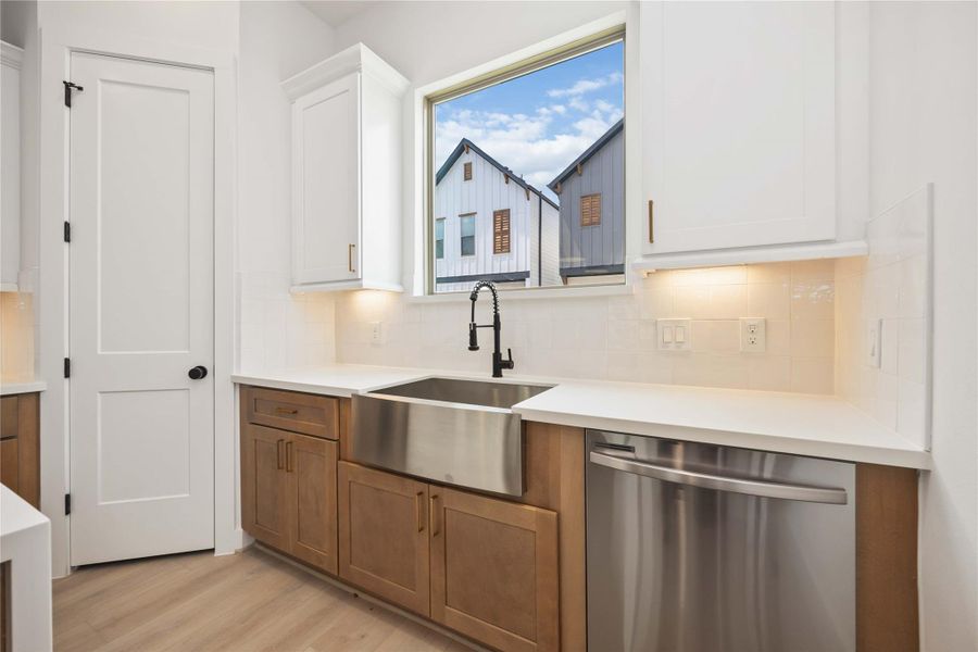 Kitchen with large farmhouse sink & stainless steel appliances. This is the base cabinet color throughout the home.