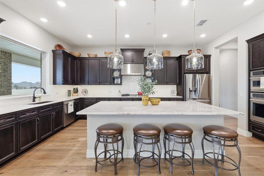 The Gourmet Cook’s Kitchen features GE Café Appliances, Cristal Gold Quartzite Island and Quartz Countertops, Upgraded Neutral Cabinetry, and a Large Picture Window capturing Golf Course and Territorial Views.