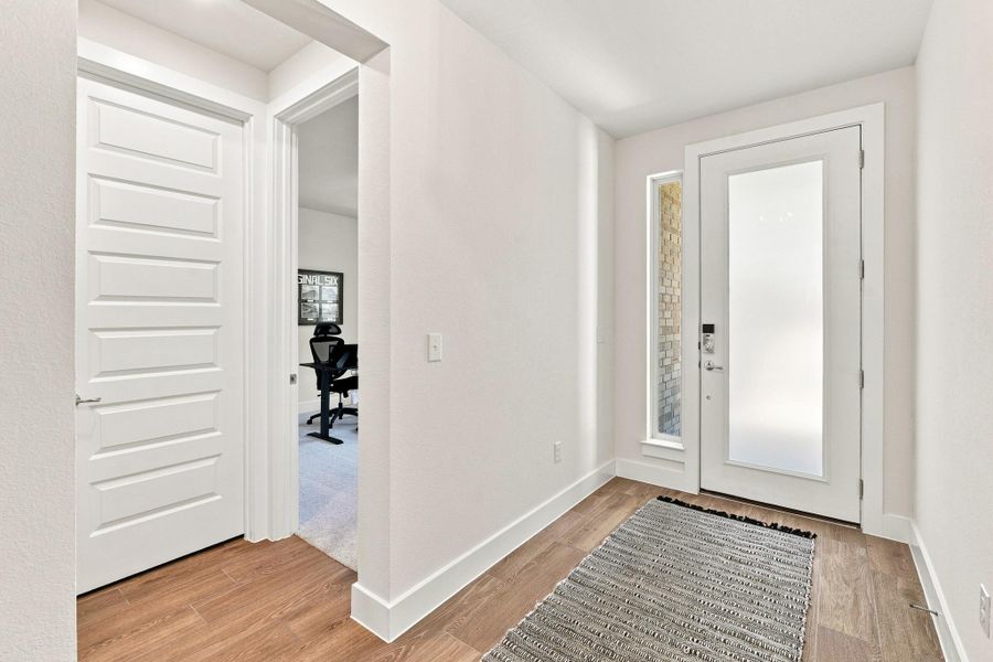 Entry hallway highlighting the main-floor guest bedroom and adjacent full bathroom. Entry hallway highlighting the main-floor guest bedroom and adjacent full bathroom.