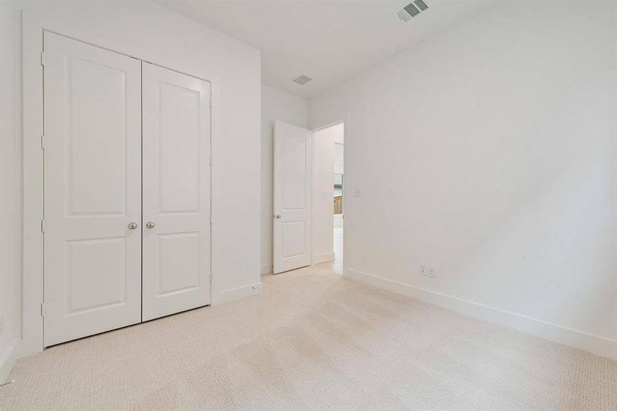 Unfurnished bedroom with light carpet and a closet Unfurnished bedroom with light carpet and a closet