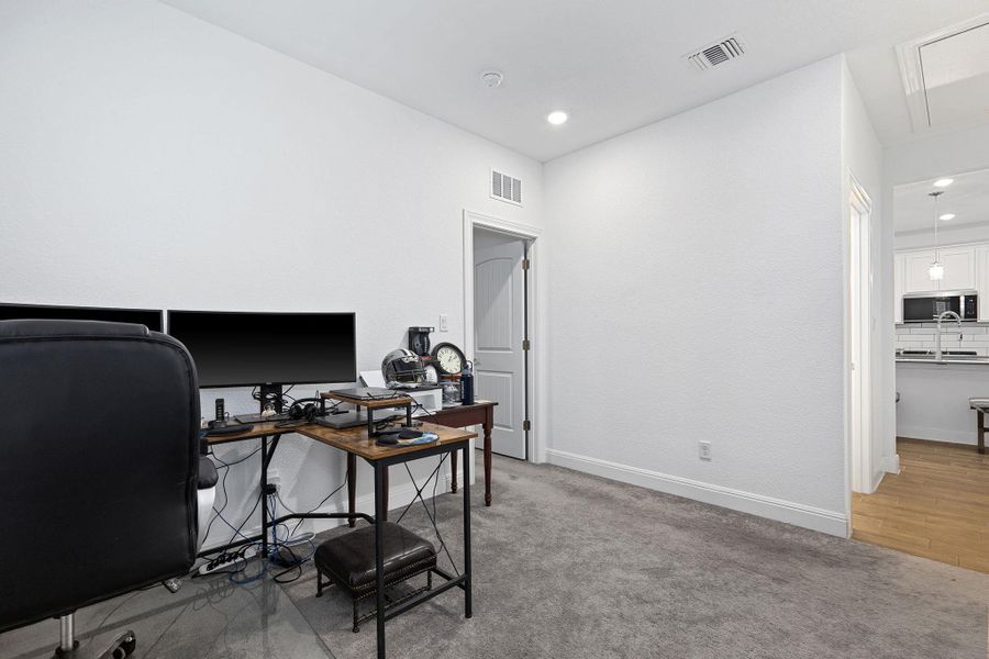 An adaptable living space features soft carpeting and direct access to a well-appointed kitchen.