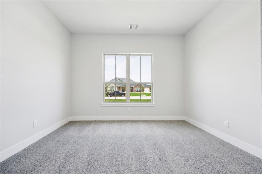 Spare room with light carpet and baseboards