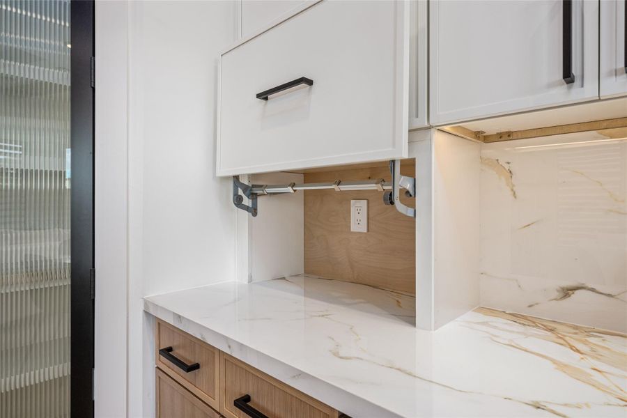 Concealed hideaway shelving makes this kitchen as functional as it is beautiful—perfect for appliances and clutter-free surfaces