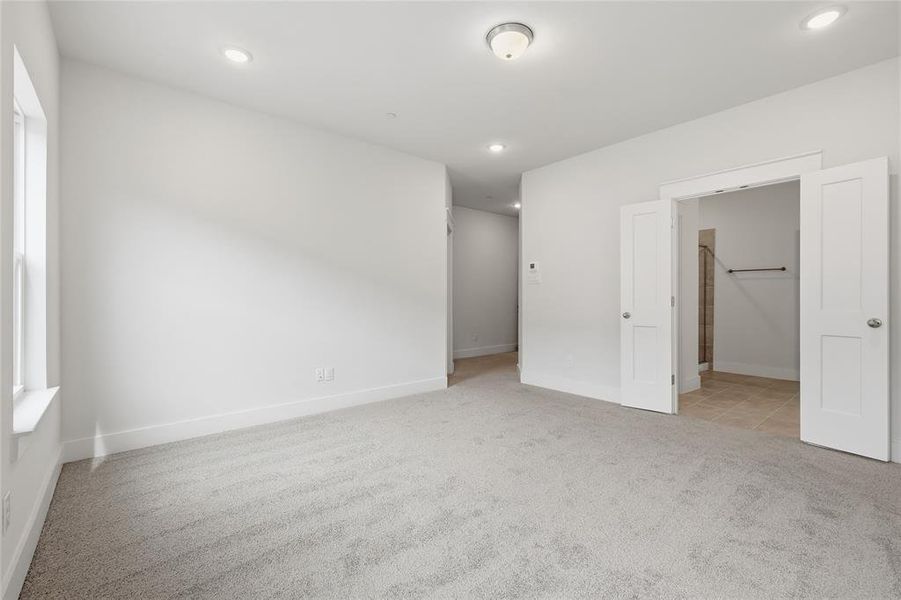 The interior features a spacious room with light gray carpet and white walls
