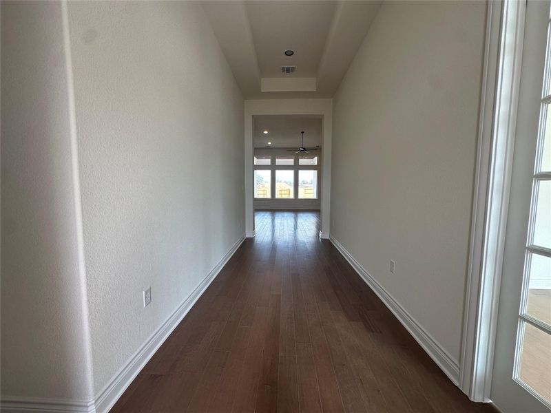 Corridor with dark wood-type flooring and recessed lighting