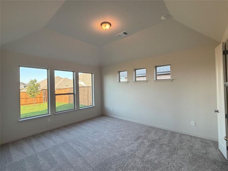 Vaulted ceiling room featuring light gray carpeting, a single ceiling-mounted light fixture, and white painted walls Vaulted ceiling room featuring light gray carpeting, a single ceiling-mounted light fixture, and white painted walls