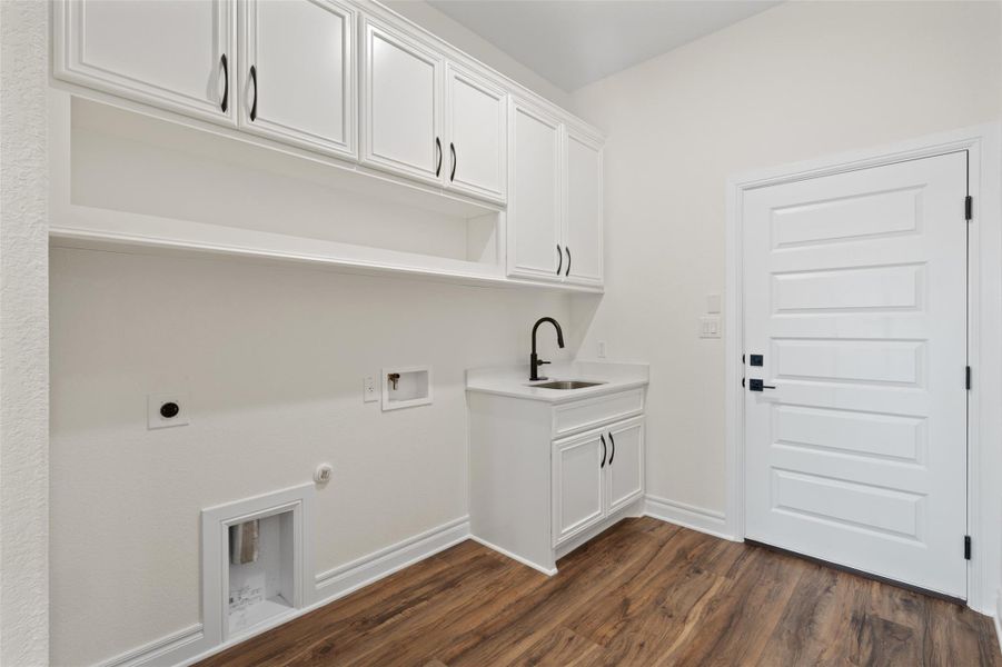 Laundry area featuring dark wood-style flooring, hookup for a gas dryer, cabinet space, and washer hookup Laundry area featuring dark wood-style flooring, hookup for a gas dryer, cabinet space, and washer hookup