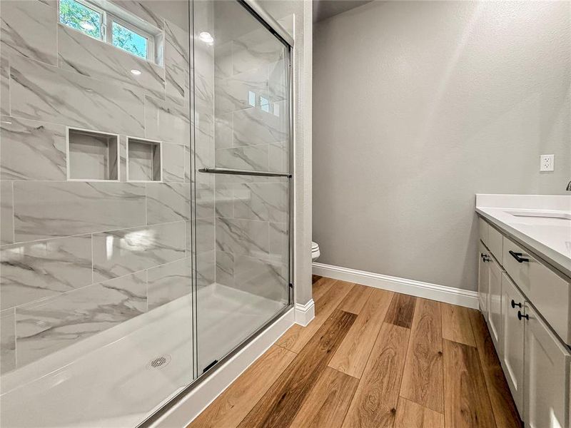 Shower with sliding glass doors, white subway tile with gray veining, and dual recessed niches Shower with sliding glass doors, white subway tile with gray veining, and dual recessed niches