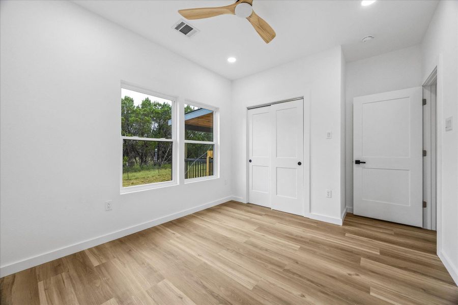 A well-lit bedroom with light wood flooring and bright white walls awaits your personal touch. A well-lit bedroom with light wood flooring and bright white walls awaits your personal touch.