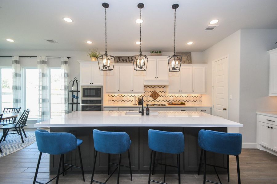 Modern flair kitchen has stone countertops and plenty of seating at the oversized island