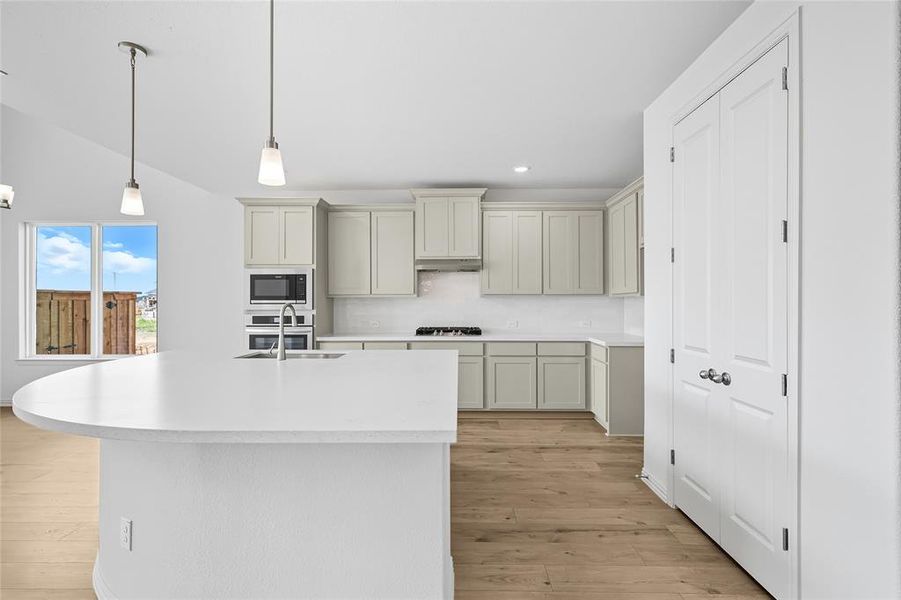 Kitchen featuring pendant lighting, backsplash, light wood-style floors, recessed lighting, and built in microwave Kitchen featuring pendant lighting, backsplash, light wood-style floors, recessed lighting, and built in microwave