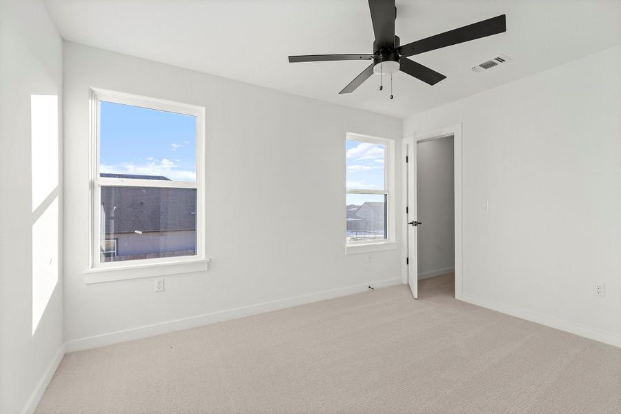 Spare room with light carpet and a ceiling fan