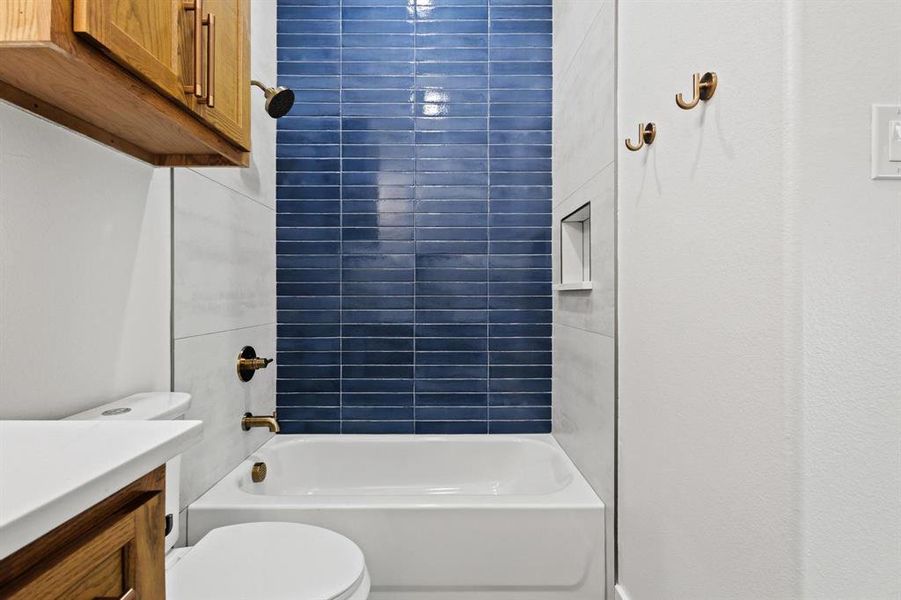 Full hallway bathroom with shower / bathtub combination and vanity