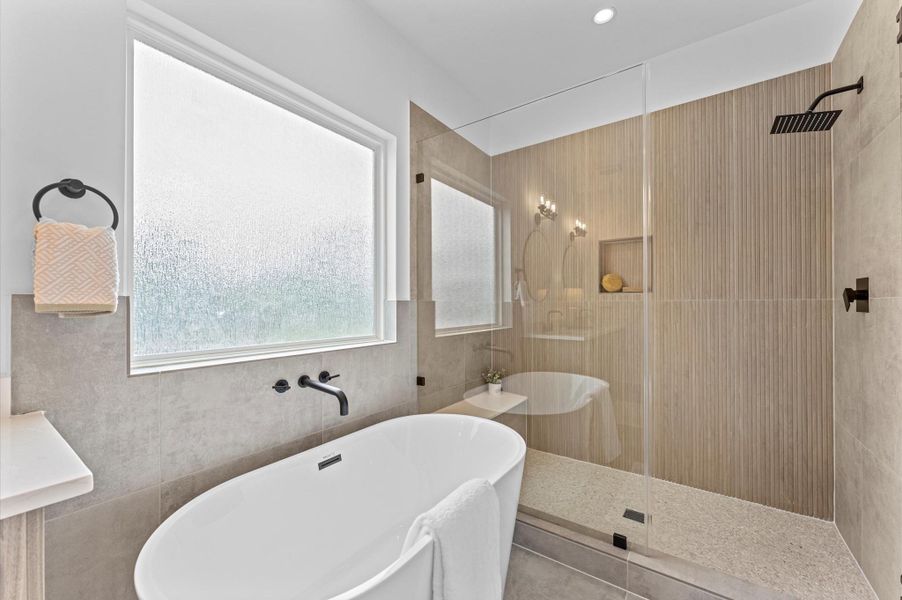 This luxurious primary bathroom blends modern elegance with spa-like comfort, featuring a spacious layout and contemporary selections throughout. A sleek double vanity with minimalist cabinetry and polished countertops offers ample storage and style, while the glass-enclosed shower includes a built-in bench for added relaxation and convenience. The centerpiece is a sculptural freestanding soaking tub, perfectly positioned to invite unwinding after a long day. This luxurious primary bathroom blends modern elegance with spa-like comfort, featuring a spacious layout and contemporary selections throughout. A sleek double vanity with minimalist cabinetry and polished countertops offers ample storage and style, while the glass-enclosed shower includes a built-in bench for added relaxation and convenience. The centerpiece is a sculptural freestanding soaking tub, perfectly positioned to invite unwinding after a long day.