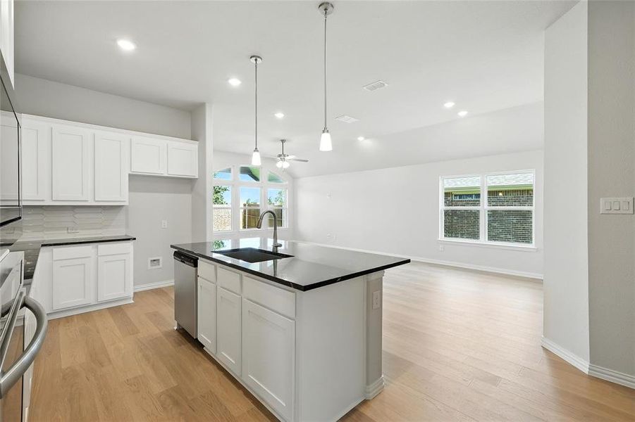 Kitchen featuring dishwasher, dark countertops, a ceiling fan, light wood-style flooring, and recessed lighting Kitchen featuring dishwasher, dark countertops, a ceiling fan, light wood-style flooring, and recessed lighting